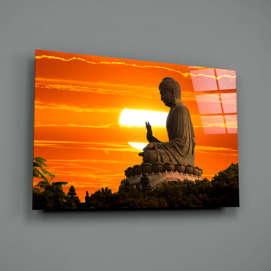 Buddha at sunset glass wall art on a plain gray wall with a window reflection in the glass