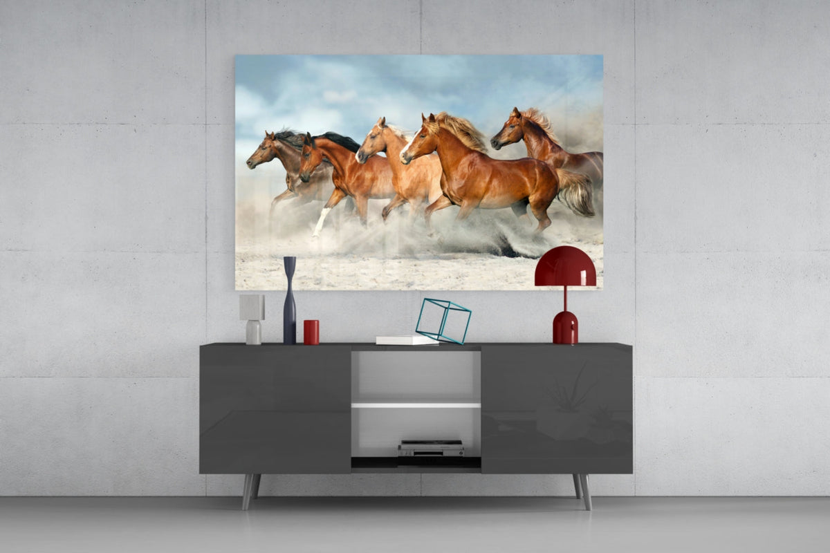 Chestnut horses galloping glass wall art above a gray sideboard with a red table lamp