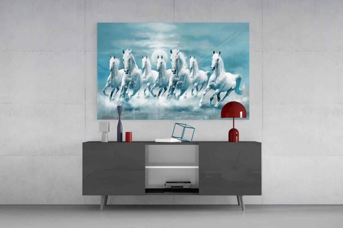 White horses in teal clouds glass wall art above a dark gray sideboard with a small red lamp