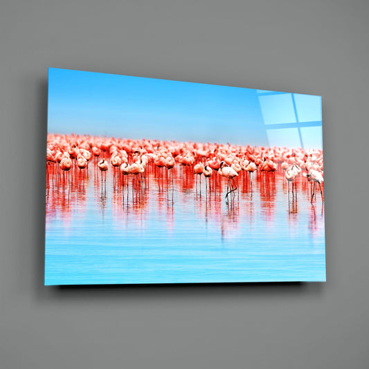 Pink flamingo flock glass wall art on a gray wall with a soft window reflection