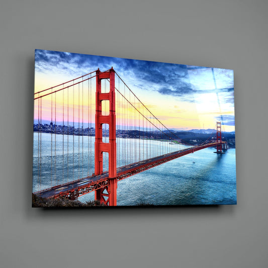 Golden Gate Bridge glass wall art on a plain gray wall, angled to show the glossy surface