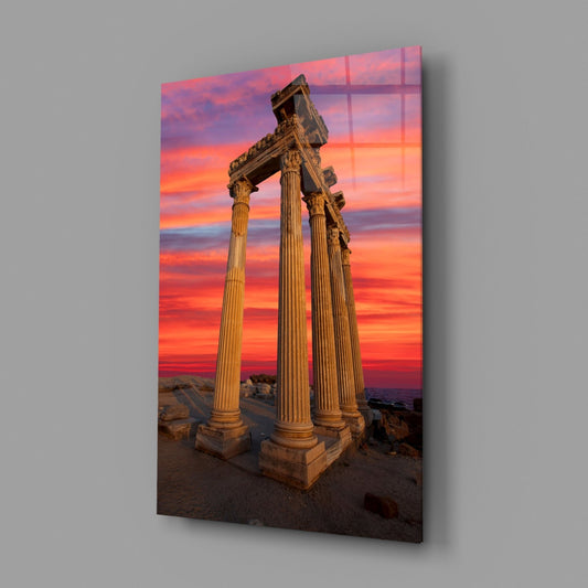 Temple of Apollo glass wall art on a plain gray wall, angled to show the glossy surface