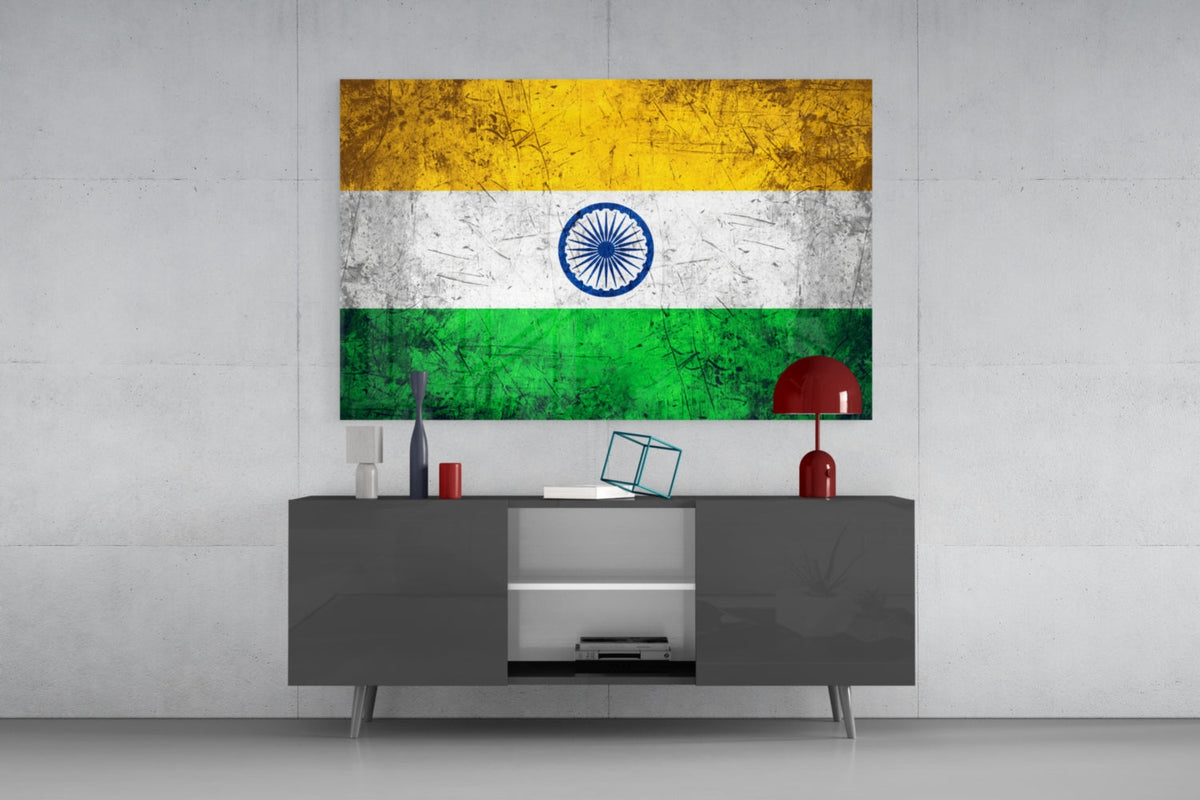 Weathered India tricolor flag glass wall art above a dark gray media console with a red table lamp