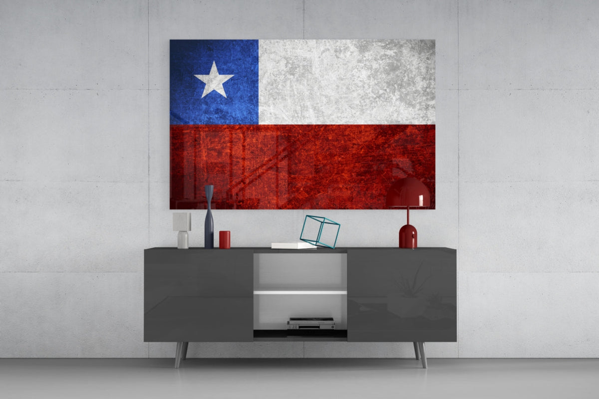 Weathered Chile flag glass wall art above a dark gray media console with a red table lamp