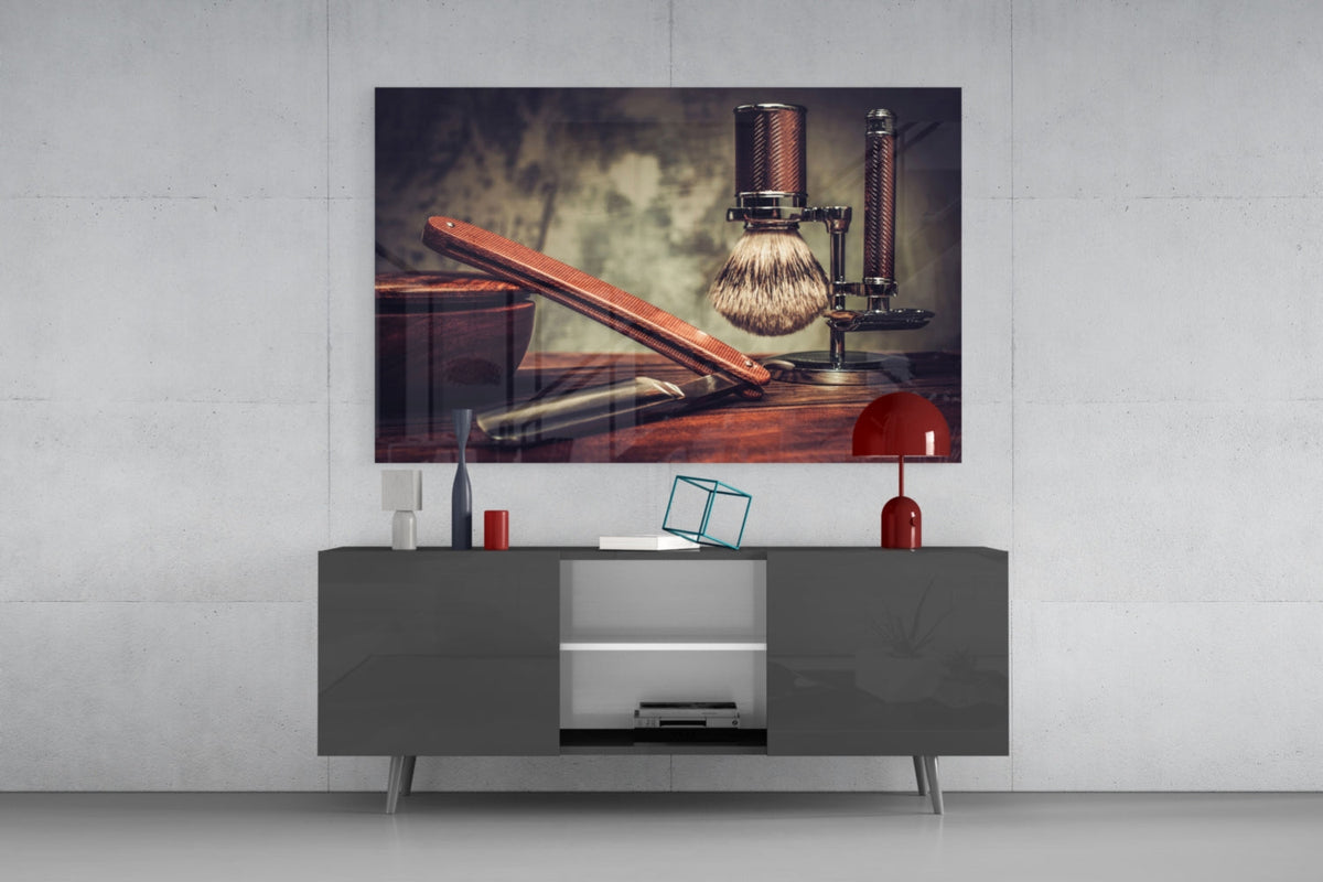 Straight razor and shaving brush glass wall art above a gray sideboard with a red lamp