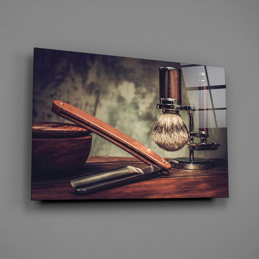 Straight razor and shaving brush glass wall art on a gray wall with a soft window reflection