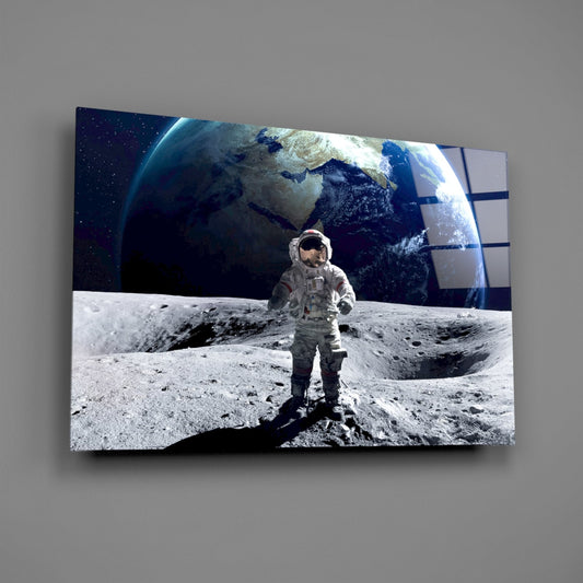 Astronaut on the moon glass wall art on a gray wall, light reflecting off the glossy front