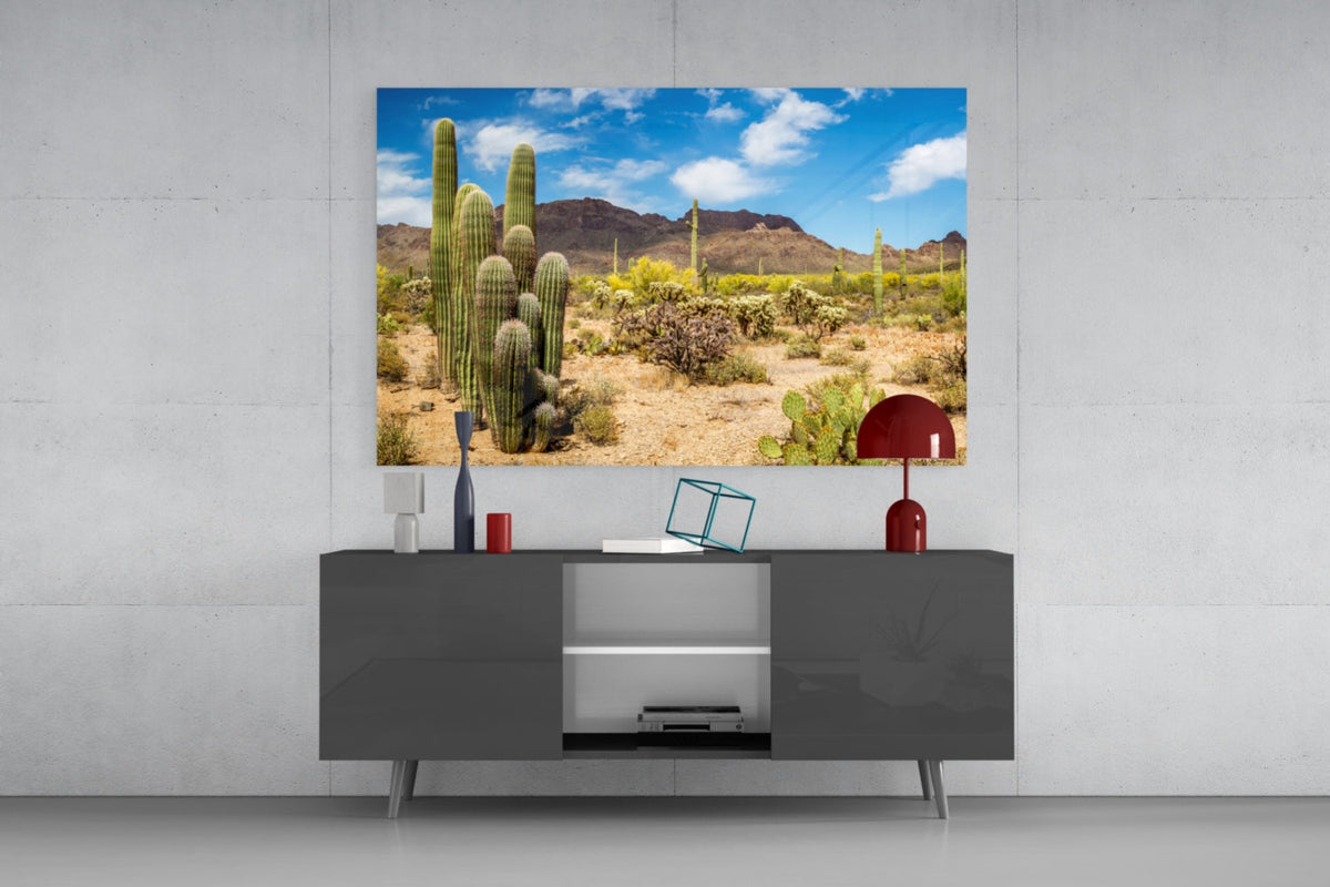 Saguaro cactus desert glass wall art above a dark gray sideboard with a red table lamp