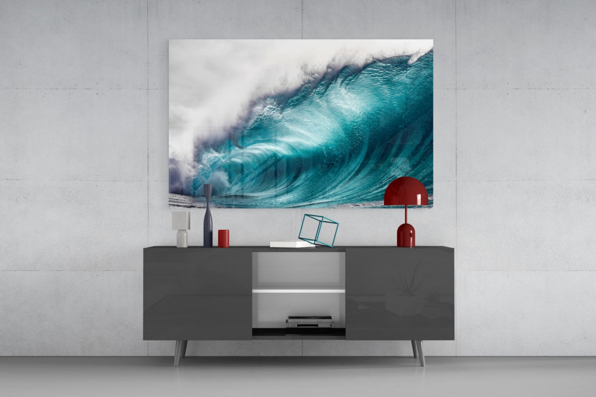 Teal wave under a pale sky glass wall art above a dark gray sideboard with a red table lamp