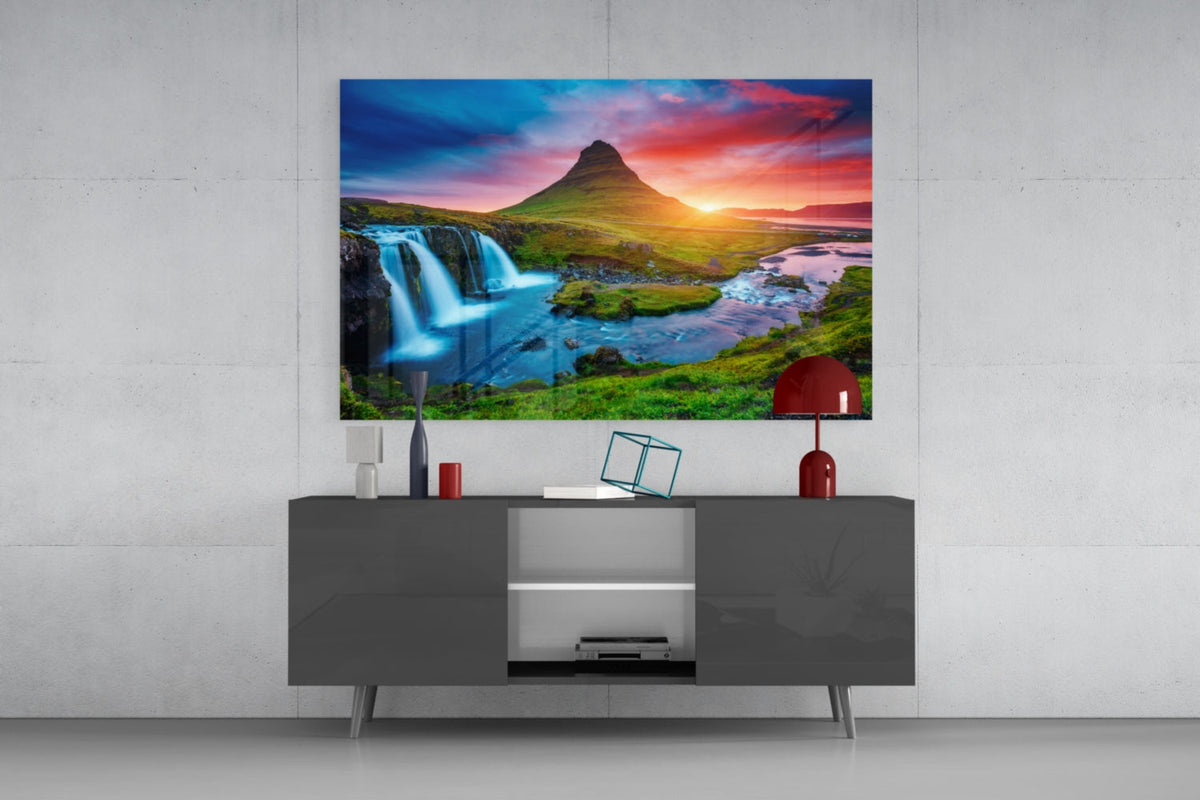 Kirkjufell mountain glass wall art above a gray sideboard with a red table lamp