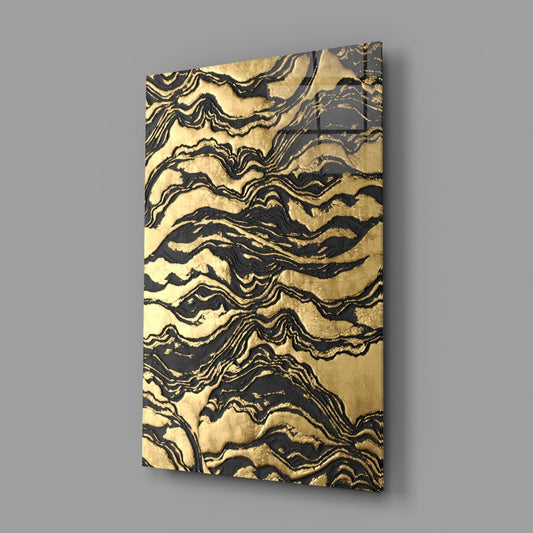 Gold and black abstract glass wall art on a gray wall, light reflecting off the glossy front