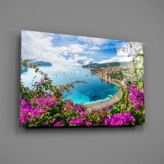 French Riviera bay glass wall art on a plain gray wall, angled to show the glossy surface