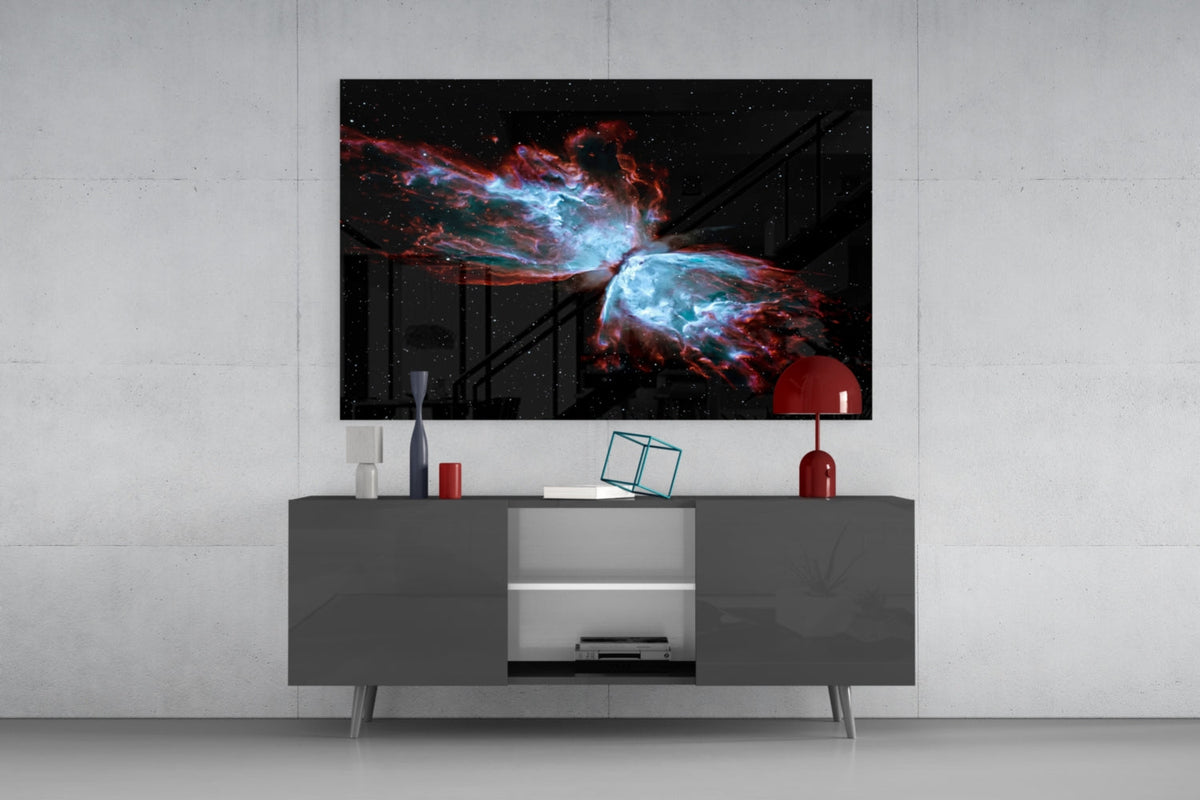 Butterfly nebula glass wall art above a dark gray sideboard with a red lamp on a concrete wall