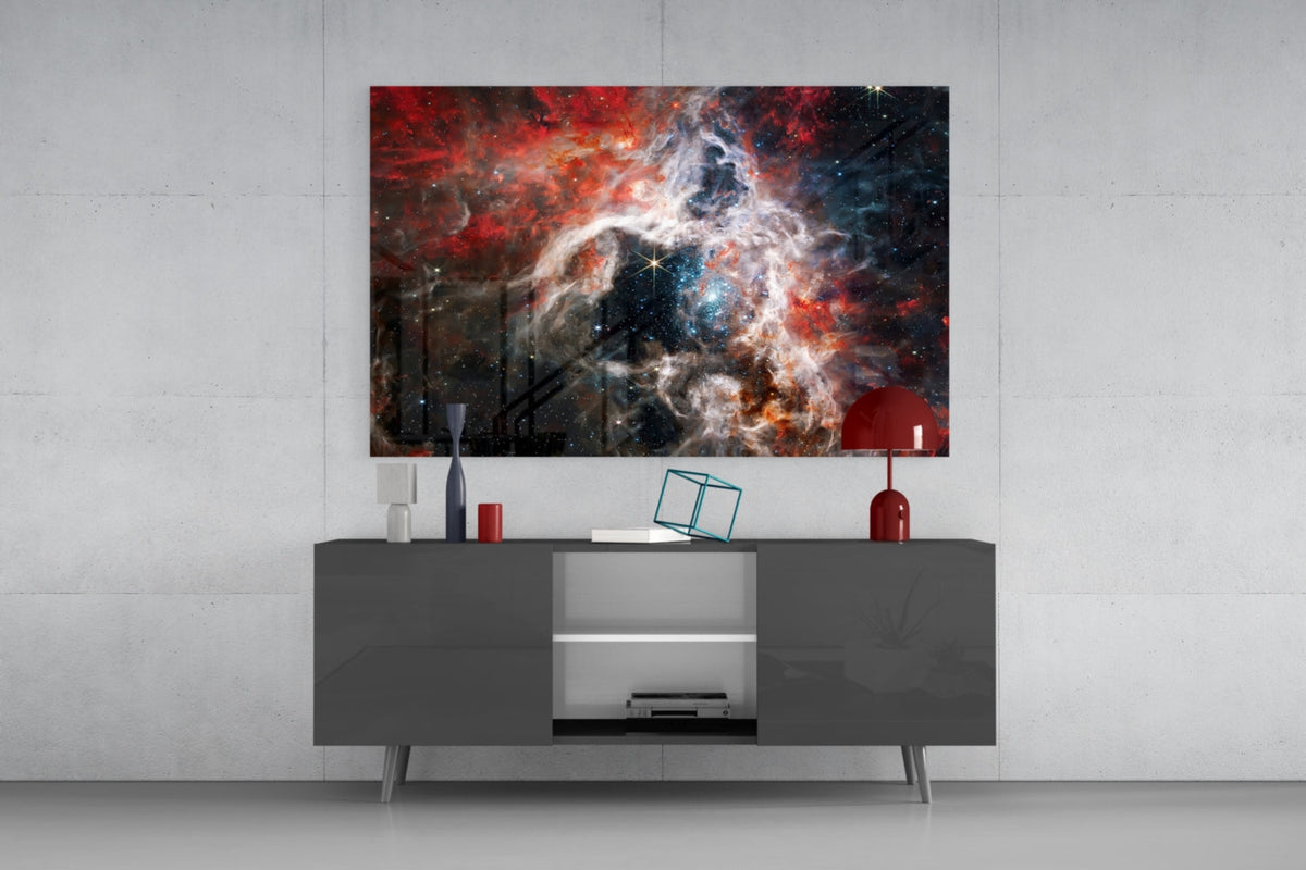 Red and white nebula glass wall art above a dark gray sideboard with a red lamp on a concrete wall