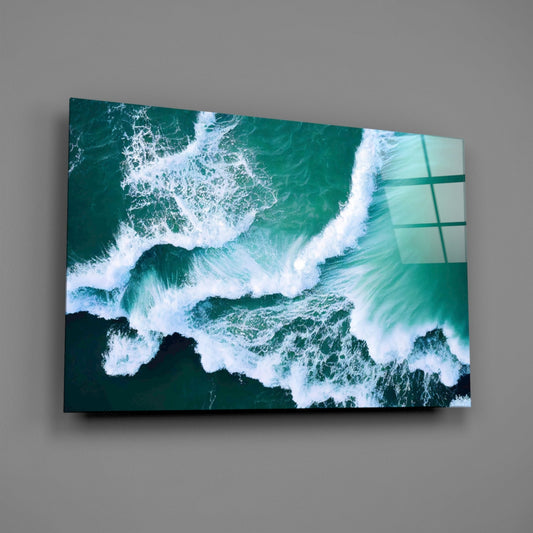 Emerald ocean waves glass wall art on a gray wall, light reflecting off the glossy front