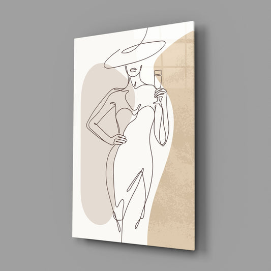 Wide hat line art woman glass wall art hanging on a plain gray wall