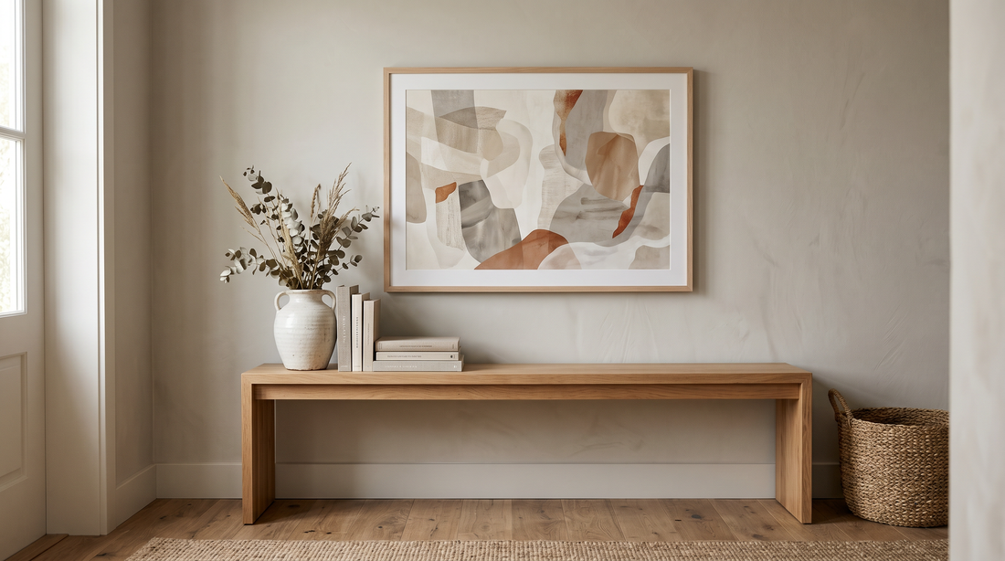 A well-proportioned framed abstract print above an entryway console, sized to about two-thirds the console width, showing correct wall art scale