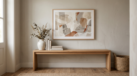 A well-proportioned framed abstract print above an entryway console, sized to about two-thirds the console width, showing correct wall art scale