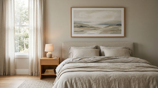 Bedroom wall decor ideas: a framed botanical print hung above a low platform bed in a calm, neutral bedroom