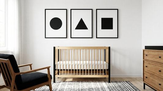 Nursery wall art for development: high-contrast black-and-white prints near a crib in a soft, calm nursery