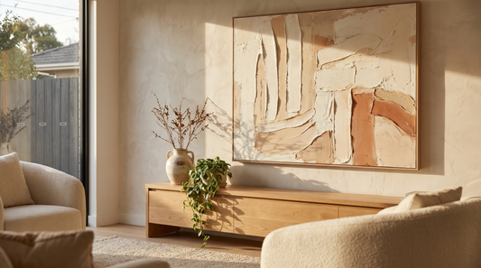 Textured wall art on a living room wall, an impasto-look canvas with raised brushstrokes catching warm side light