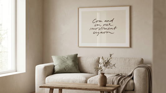 Modern christian wall art ideas: a framed minimalist scripture print in a clean typeface above a neutral sofa in a contemporary living room