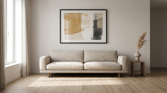 Modern wall art ideas: a framed abstract print above a low sofa in a calm, neutral living room