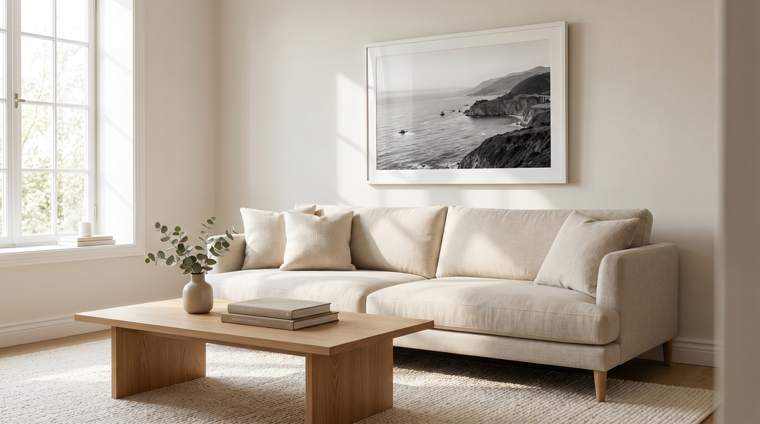 Black and white wall art framed in white above a linen sofa in a calm living room