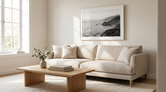 Black and white wall art framed in white above a linen sofa in a calm living room