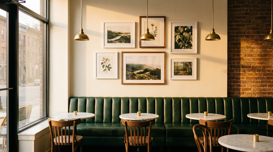 Restaurant wall decor ideas with a framed gallery wall above a leather banquette in a warm cafe
