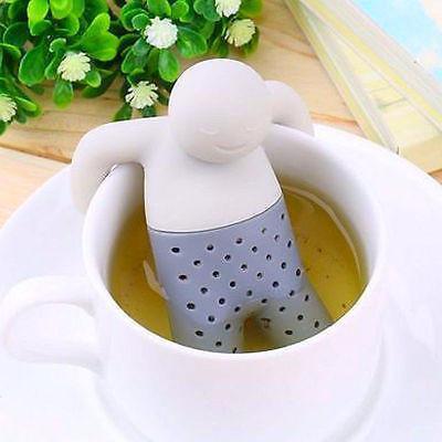 Silicone tea infuser shaped like a person in a cup of tea with green leaves in the background