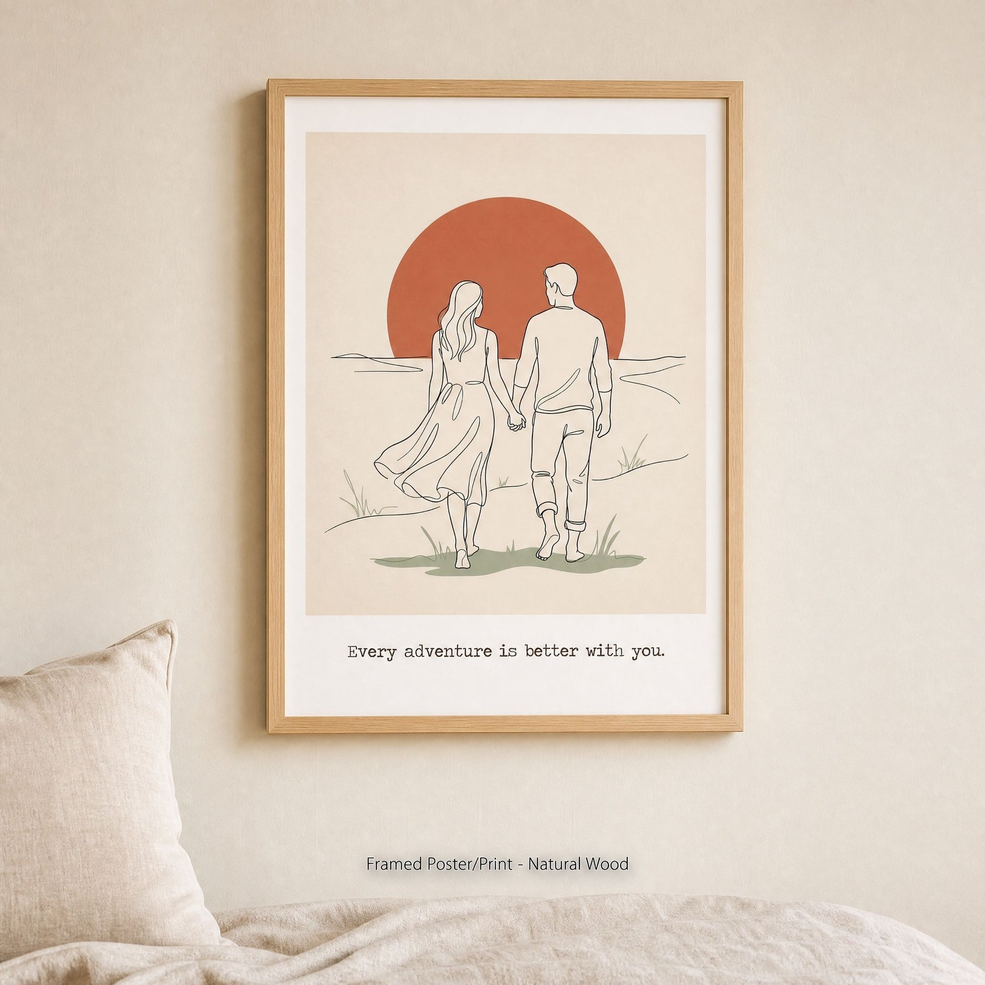 The same couples print in a light natural wood frame, hung above a bed with soft linen pillows.