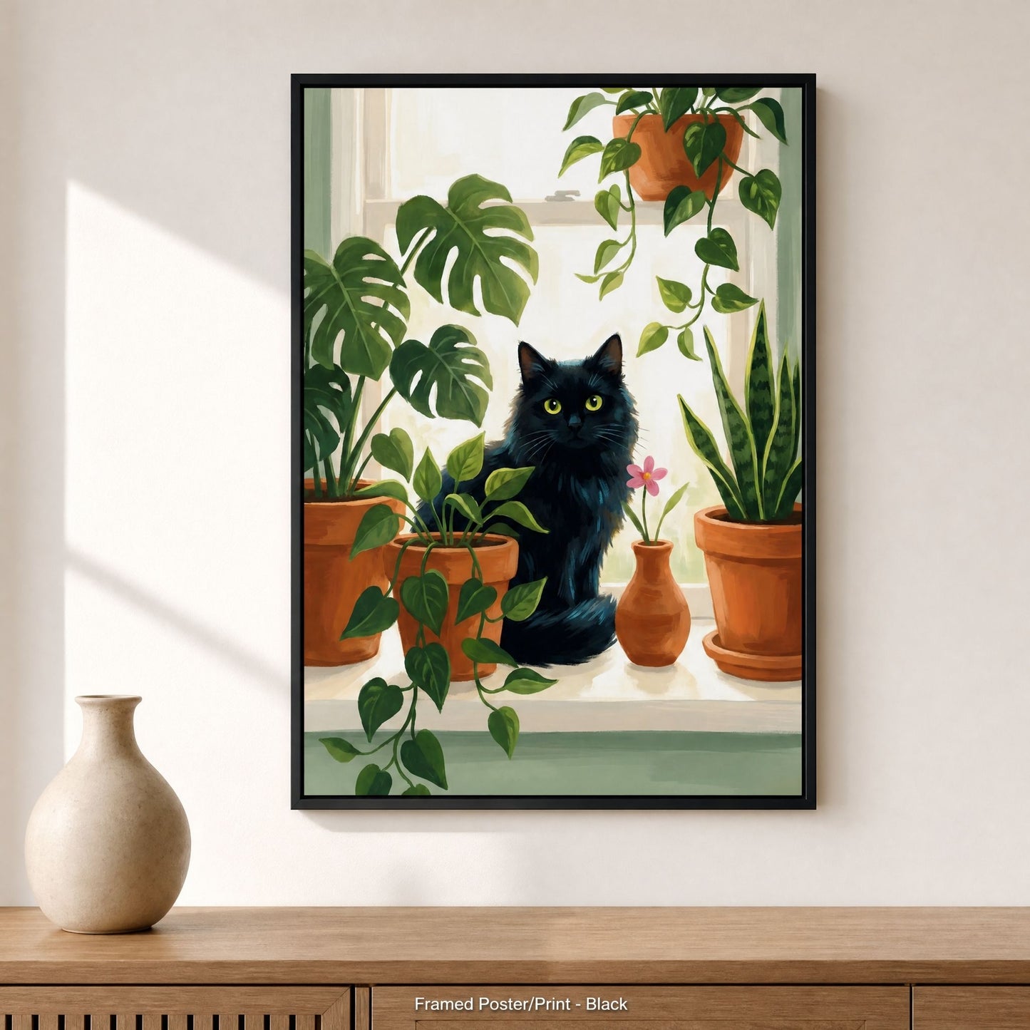 Black cat botanical print in a black wood frame above a console table with a pale ceramic vase