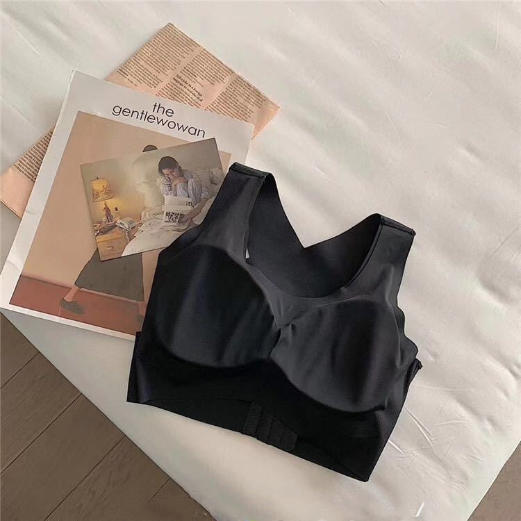 Black bralette on a white surface with a magazine underneath