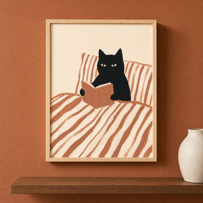 Framed cat reading print above a console with a ceramic vase, terracotta bookish wall art