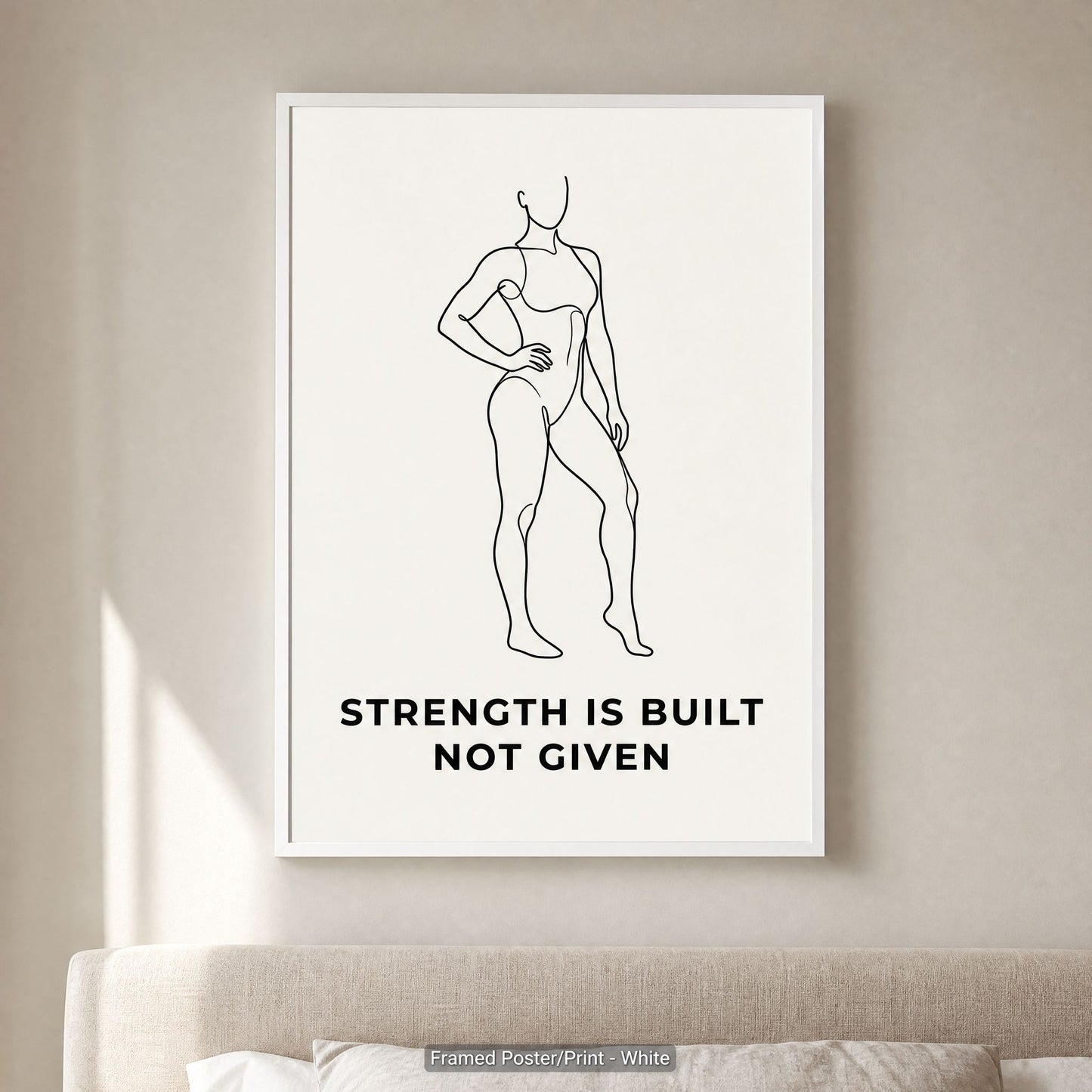 White frame option on a pale wall above a cushioned sofa, minimalist wall art in a calm neutral room