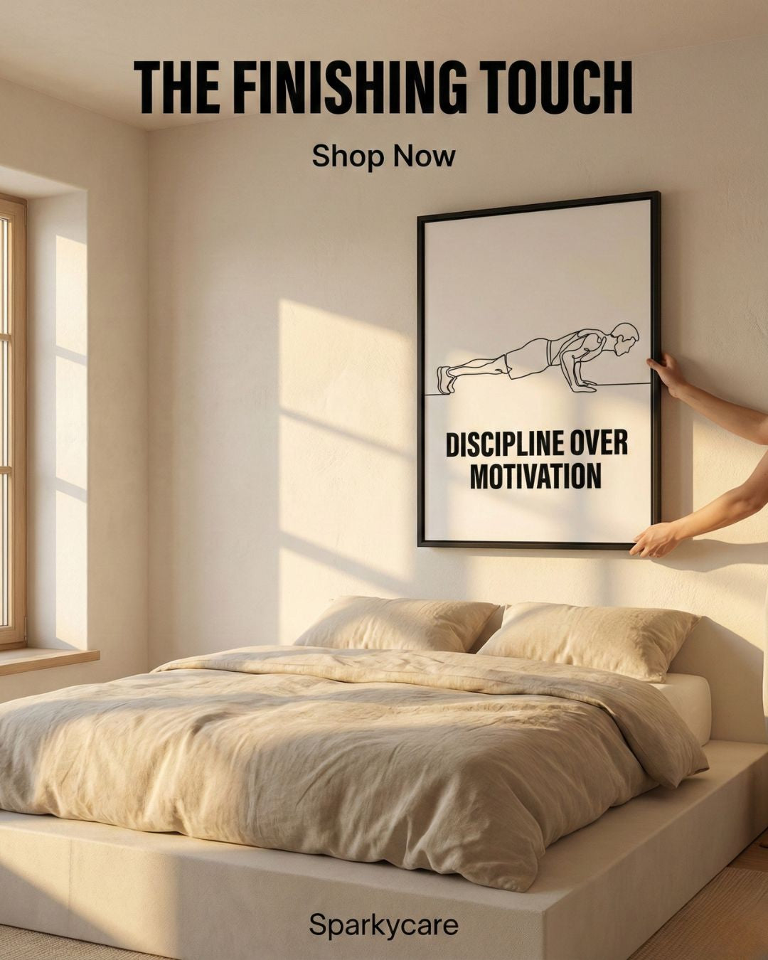 Framed artwork titled 'Discipline Over Motivation' being hung on a wall above a bed in a bedroom.