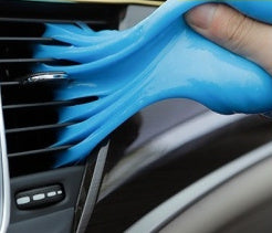 Pressing cleaning gel into car air vent to remove dust