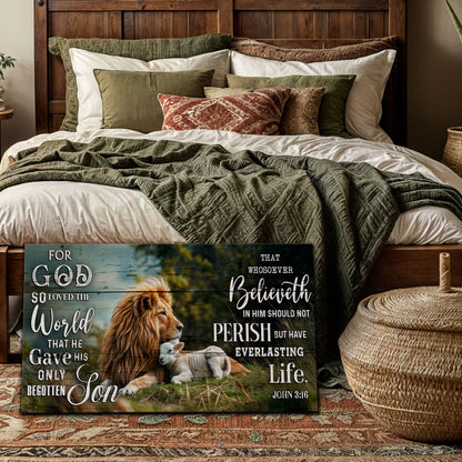 Wide canvas of a lion and a lamb lying in a green meadow with John 3:16 in white lettering, leaning at the foot of a bed