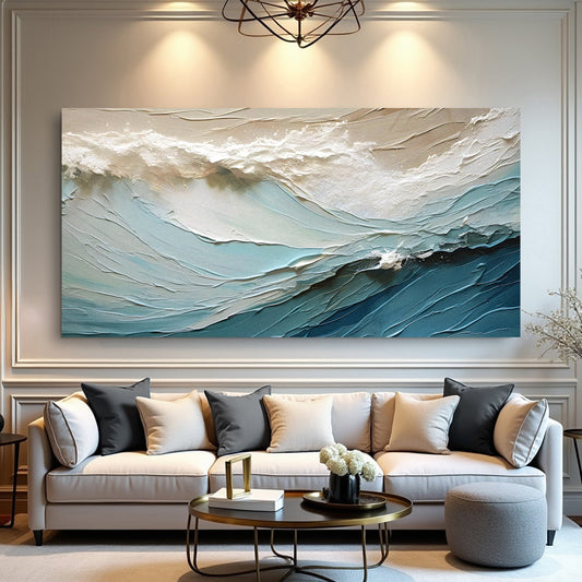 Canvas printed with a cream and blue sea wave in a sculpted-plaster look, hung above a grey sofa