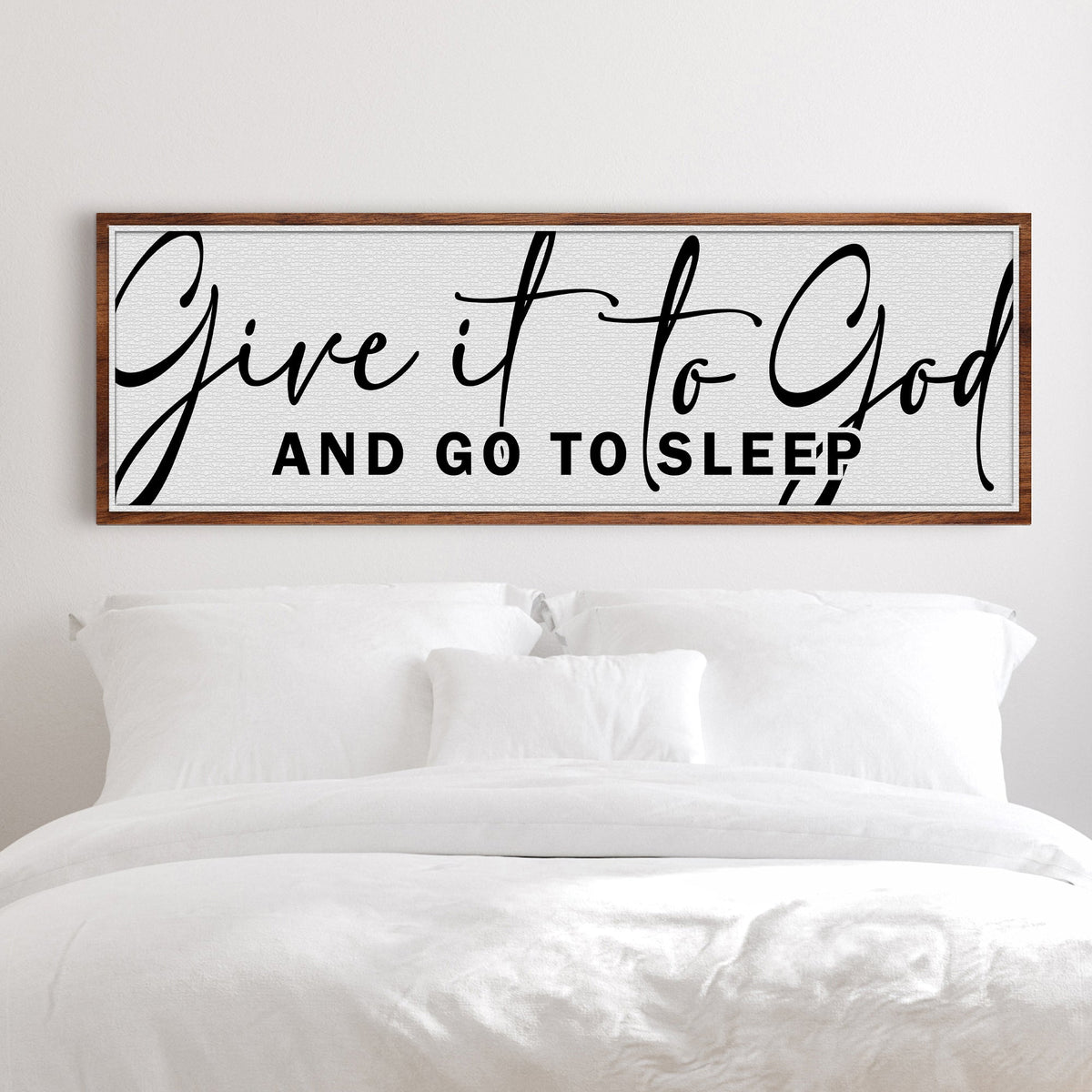 Long white canvas sign with large black script Give it to God and capitals And Go To Sleep, above a white bed