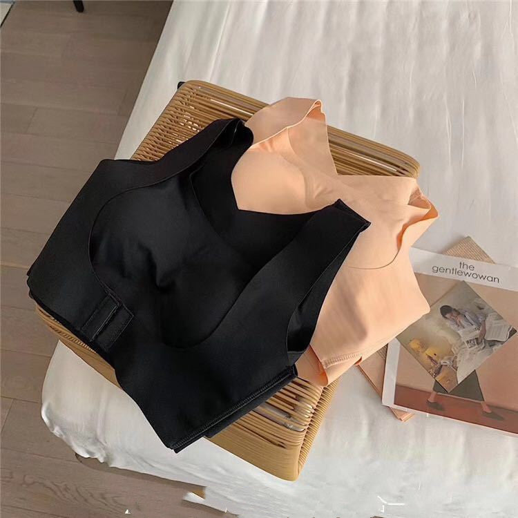 Black jacket draped over a beige garment on a white surface with a magazine underneath.