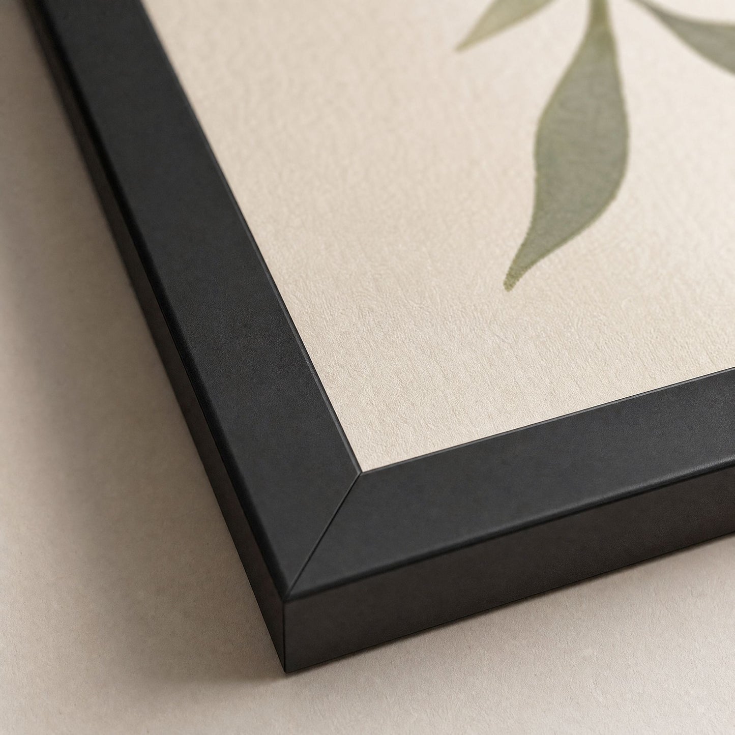 Close-up of the black frame corner and matte paper edge on a kintsugi pottery print, showing the mitred joint