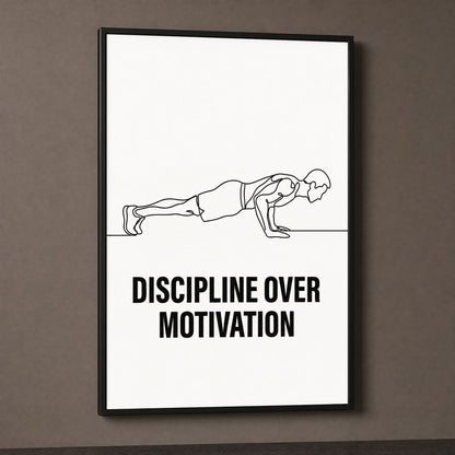 Discipline Over Motivation print in a black frame on a dark taupe wall, lit from the side