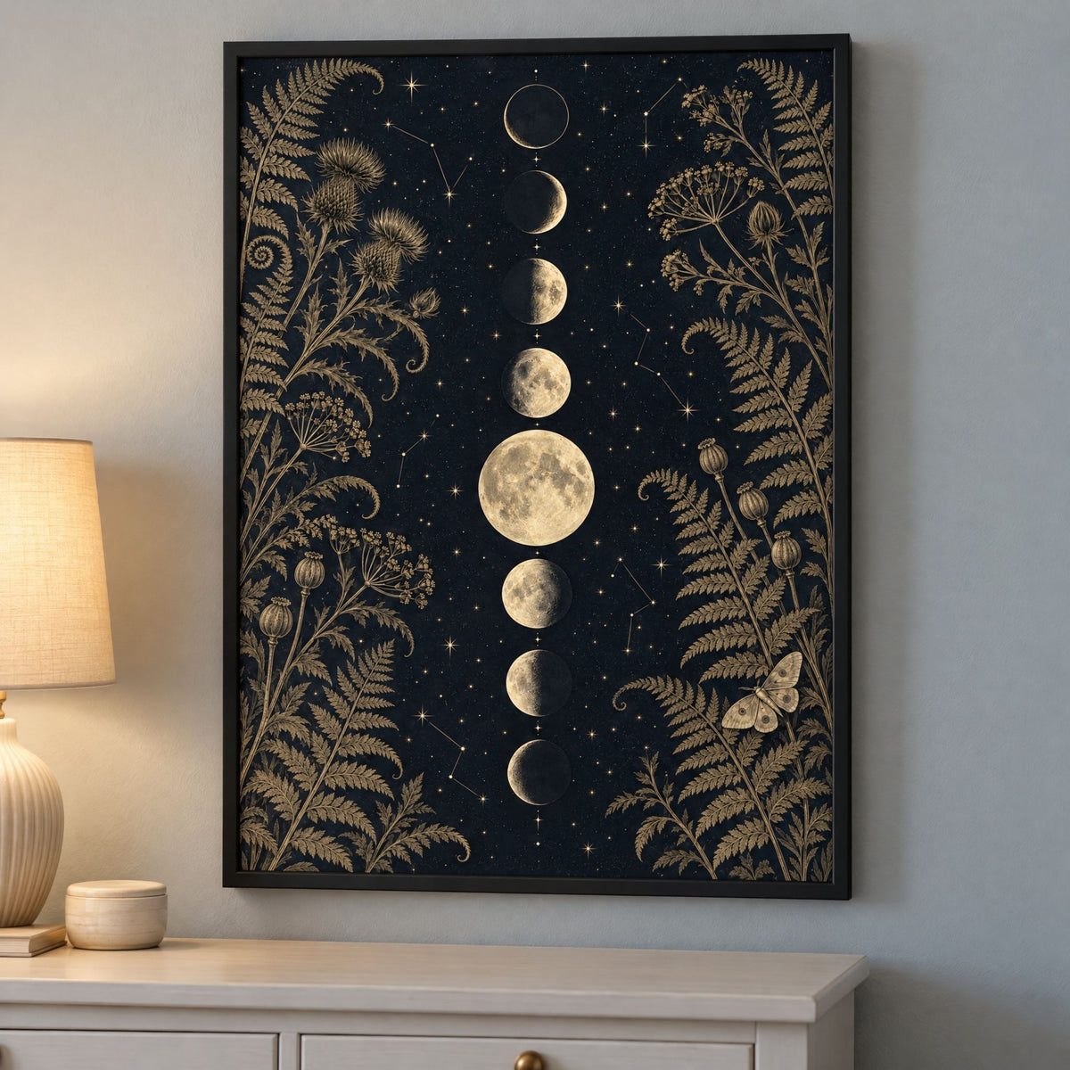 Black and gold moon phase print framed in black above a bedroom dresser, gothic wall art for a calm bedroom