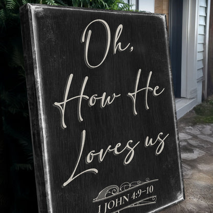 Angled close-up of the black Oh How He Loves Us canvas sign with white script
