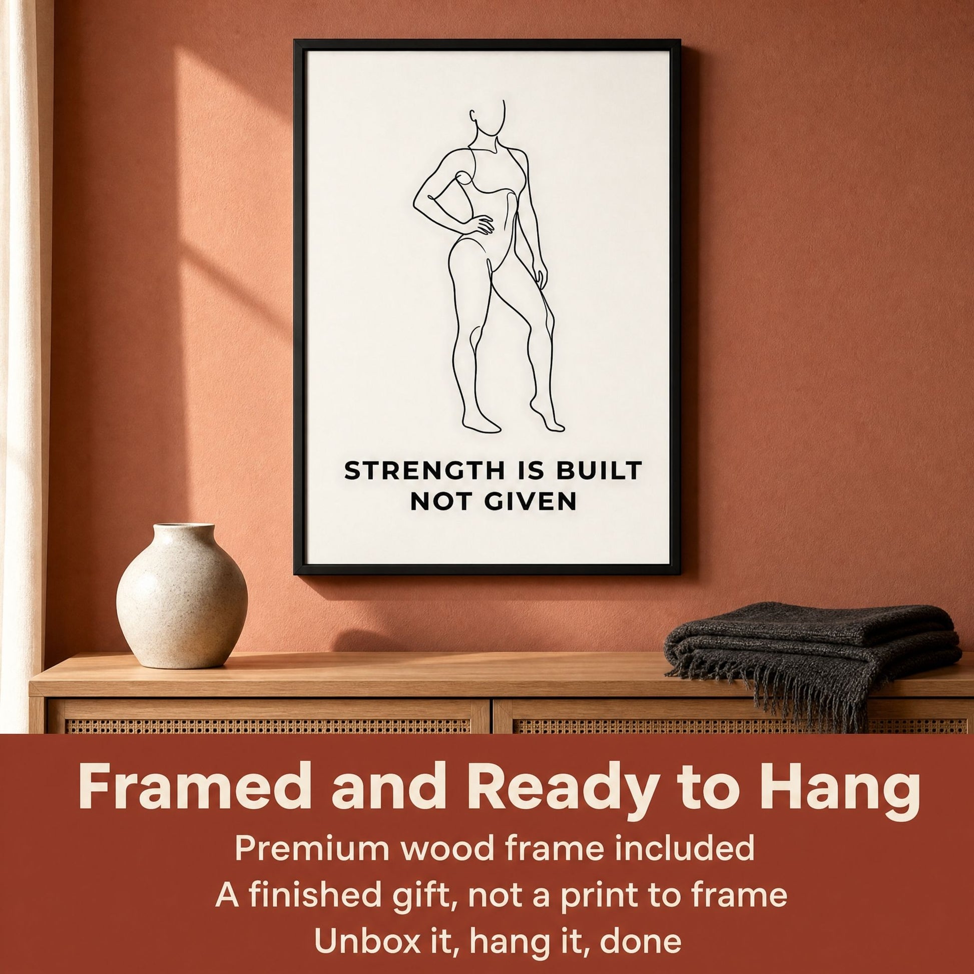 Framed Strength Is Built Not Given print on a wood sideboard, with an overlaid panel about the included frame