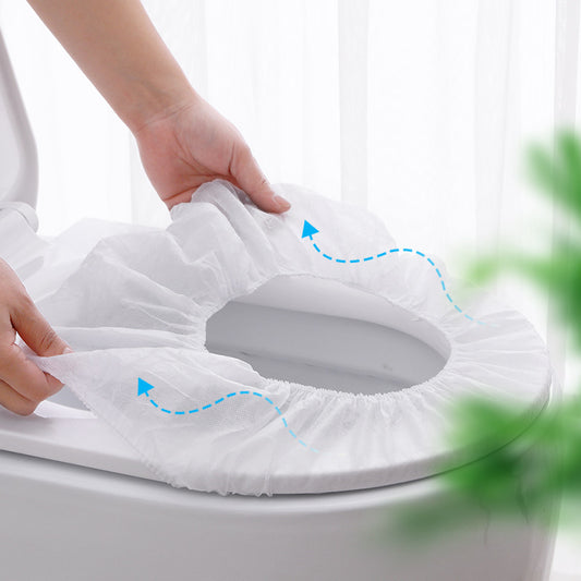 Person stretching elastic disposable toilet seat cover over toilet