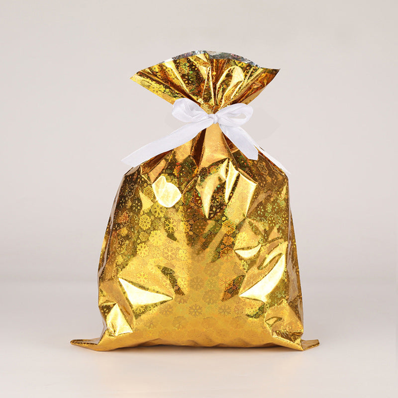 Gold gift bag with a white ribbon on a light gray background