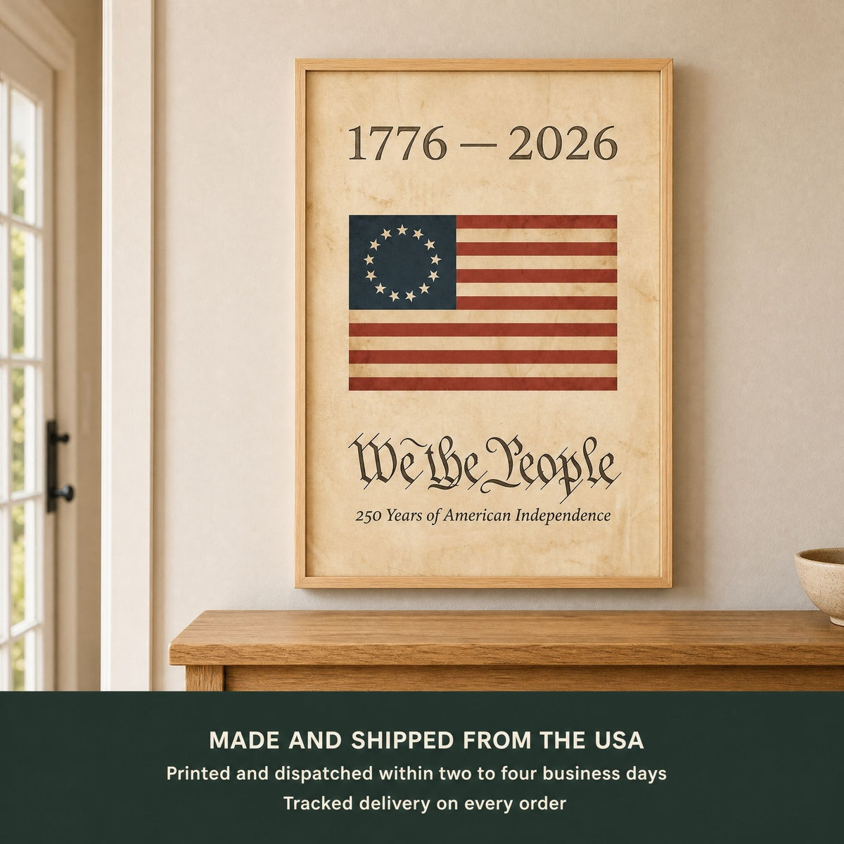 Framed 1776 American flag wall art above an oak entry console, with a panel giving production times and tracked delivery on every order